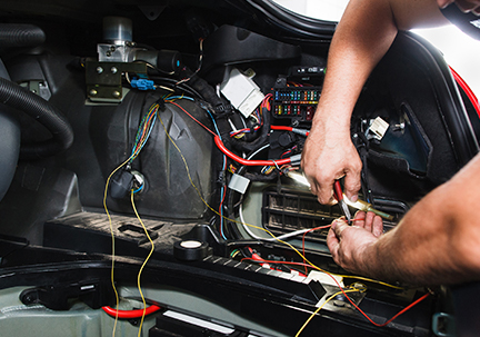 hands working on car electronics
